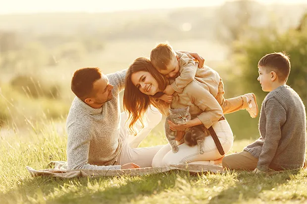 Foto de uma familia feliz brincando ao ar livre.
